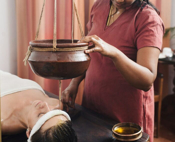 Caucasian woman having Ayurveda shirodhara treatment in India, Kerala state