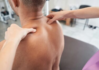 Man reconceiving massage treatment in physiotherapy clinic